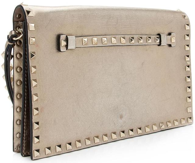 https://cdn.reebelo.com/pim/products/P-VALENTINOMETALLICNAPPALEATHERROCKSTUDCLUTCH/GOL-image-1.jpg